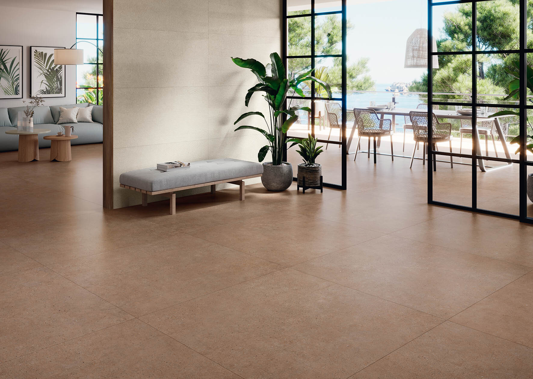 Sal&oacute;n en tonos tierra con suelo porcel&aacute;nico terracota abierto a la terraza